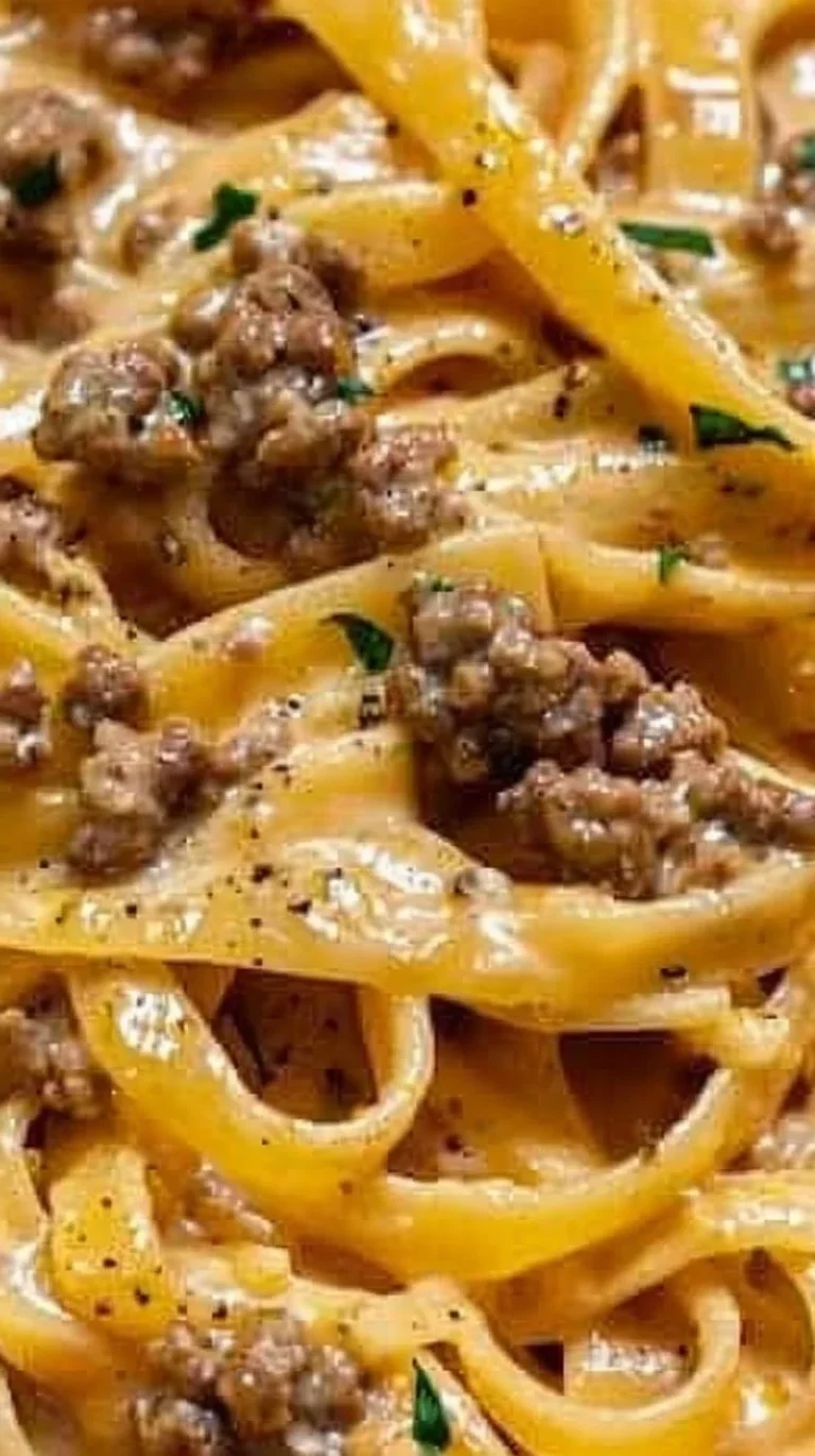 Plate of creamy garlic butter pasta with ground beef, garnished with parsley.