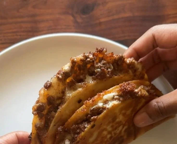 Crispy ground beef tacos topped with lettuce, cheese, and salsa